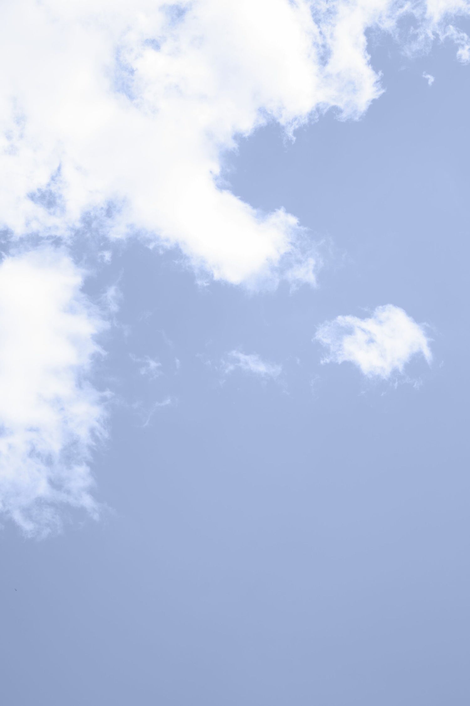 Background image of a photo of a blue sky with white clouds in the upper left half of image.