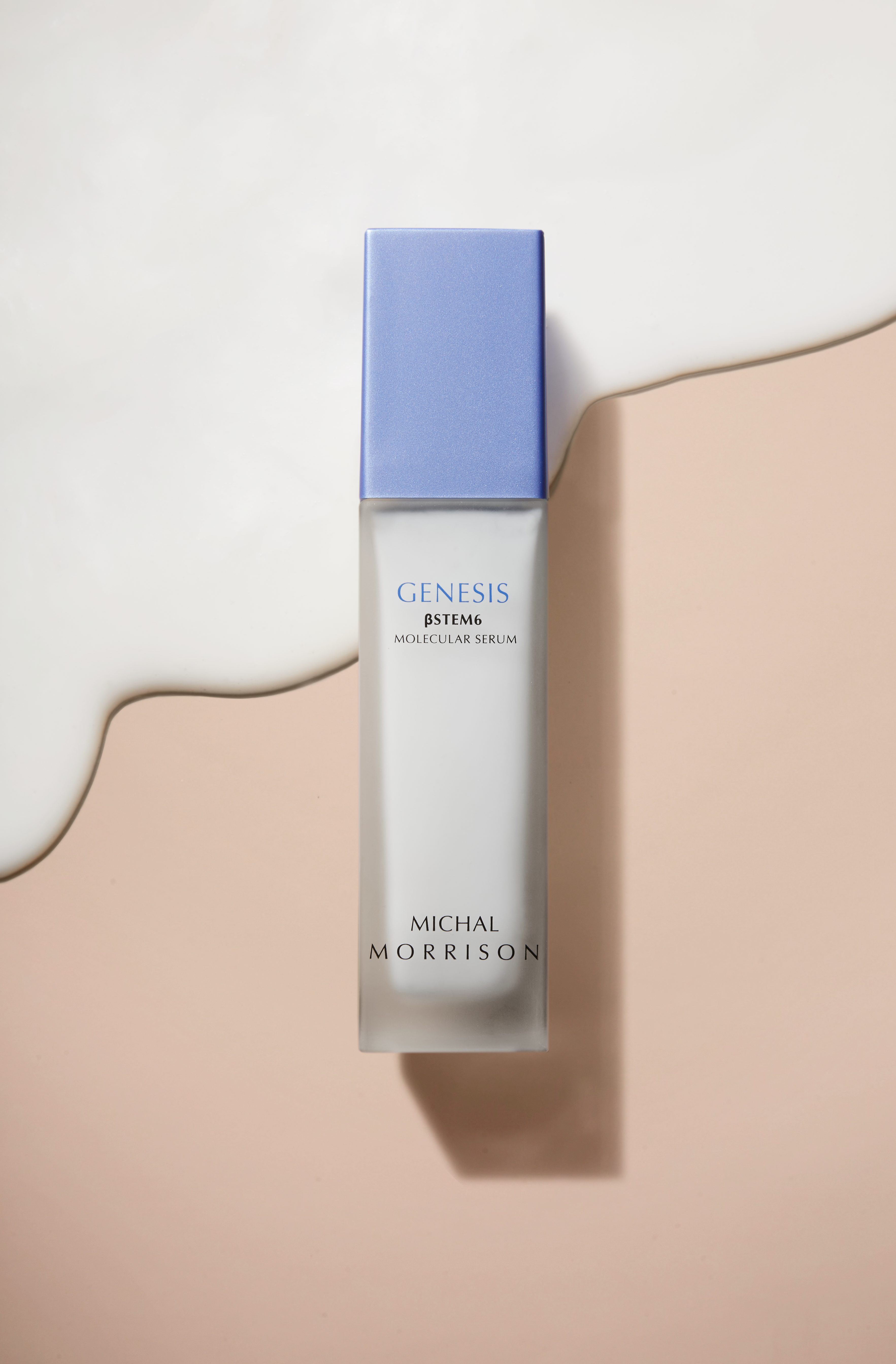Image of Michal Morrison Genesis BSTEM6 Molecular Serum in clear package with periwinkle cap laying on top of salmon pink background