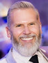 Headshot of reviewer Ken P. showing a man with a gray beard dressed in a suit and tie smiling at camera.